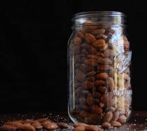 Jar full of healthy roasted almonds sitting on the table
