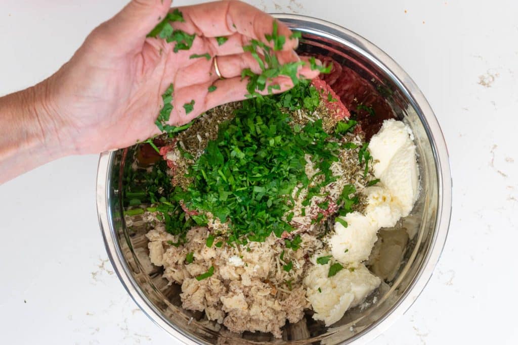 Add parsley to meatball mixture.