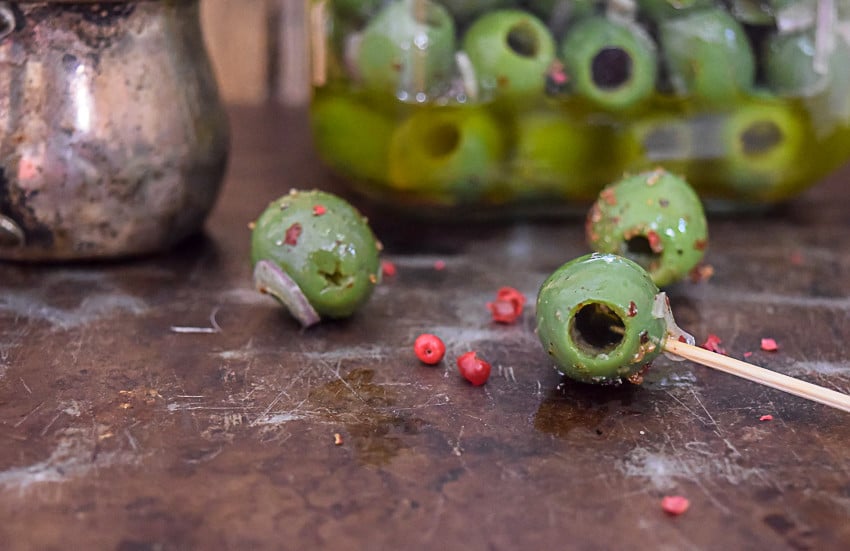 A recipe for Marinated Castelvetrano olives with shallots, garlic and pink peppercorn. Perfect for snacking and appetizers.