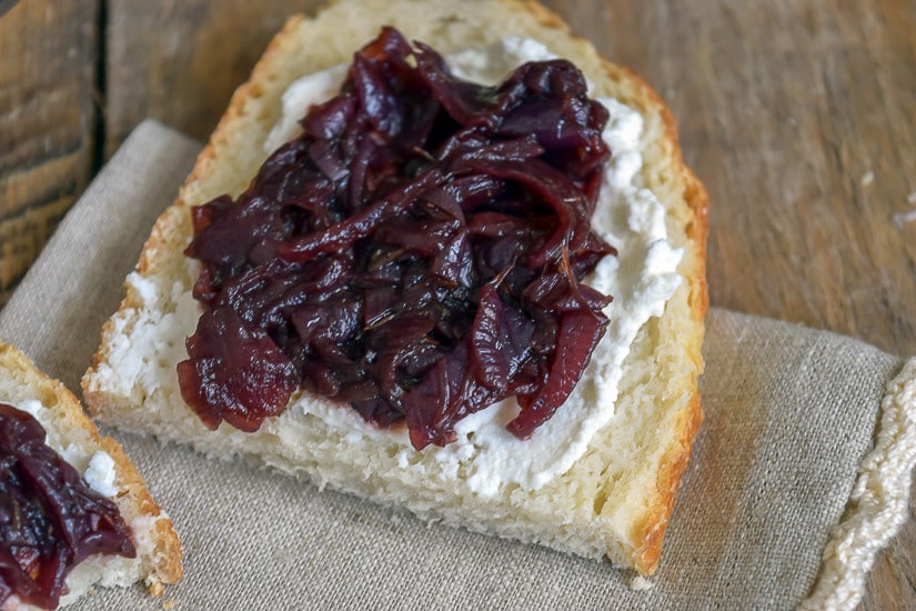 Savory Red Onion Jam Recipe: close up of onion jam on bread with goat cheese 