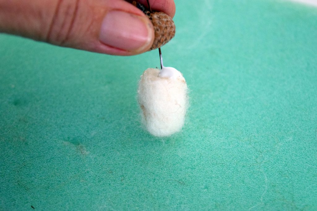 Putting the cap on acorn. Illustrated Instructions to make needle felted acorns and needle felted acorn napkin rings. Perfect for your Fall and Thanksgiving table.