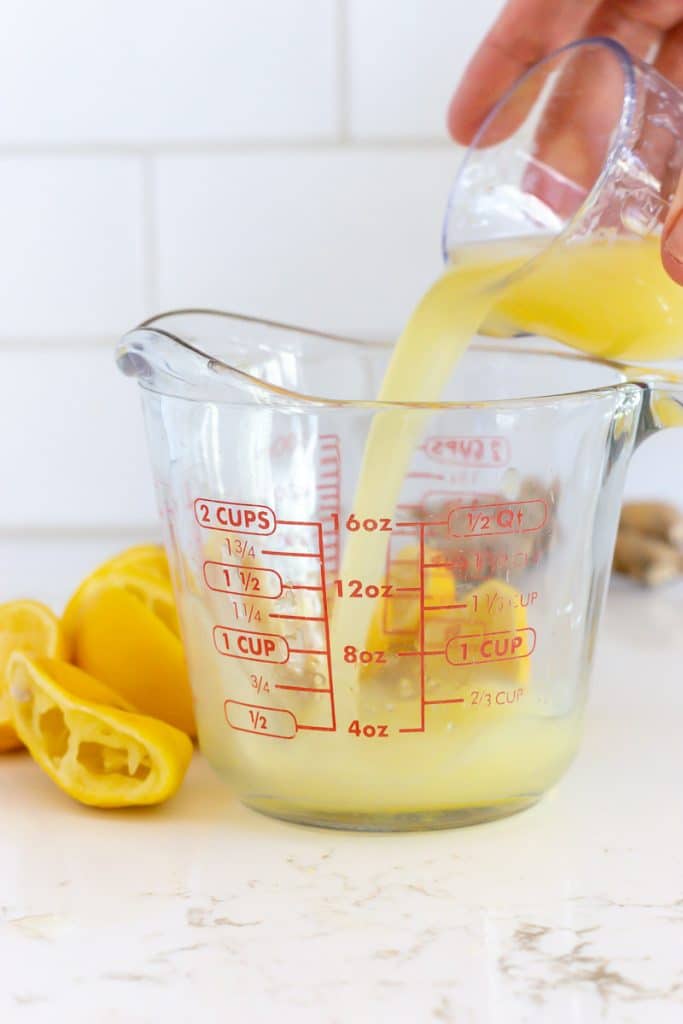 Pour lemon juice into a measuring cup.