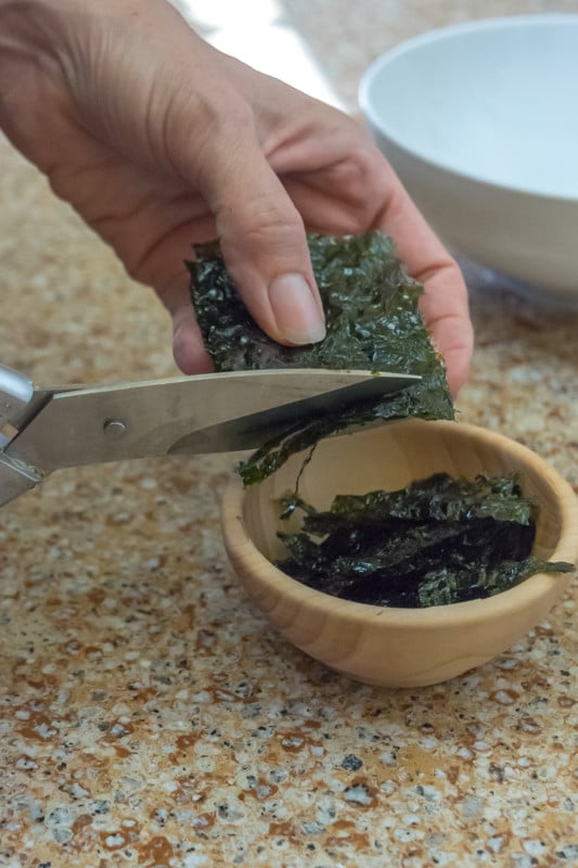 Shrimp Sushi Bowl recipe ingredients: close up of seaweed being cut and prepped