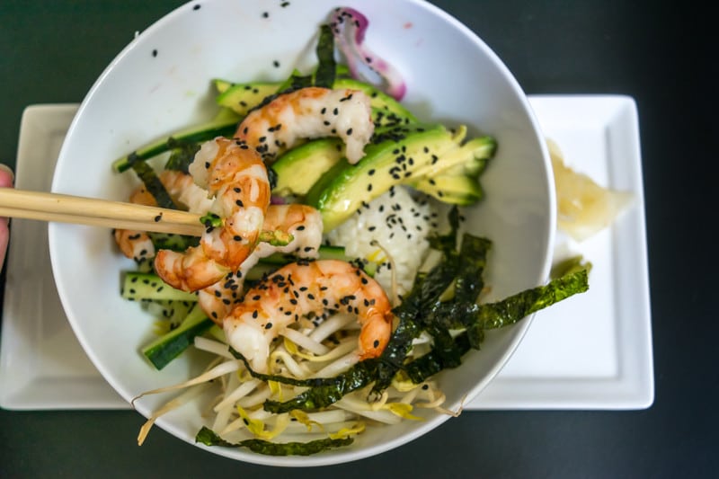 Shrimp Sushi Bowl: overhead view of  completed bowl served with marinated shrimp, avocado, rice, sea weed and bean sprouts
 