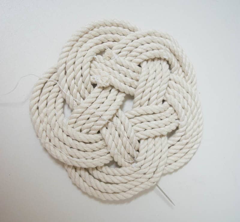 A Flat Turk's Head Knot is perfect for diy coasters & trivets: Close up of tieing off finished Turks Head Knot rope coaster