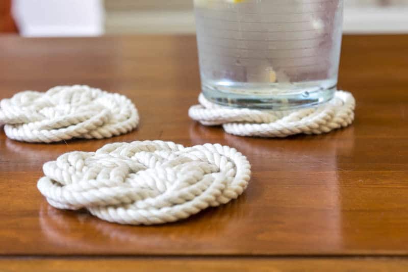 A Flat Turk's Head Knot is perfect for diy coasters & trivets: Close up of coffee table with glass on rope coasters