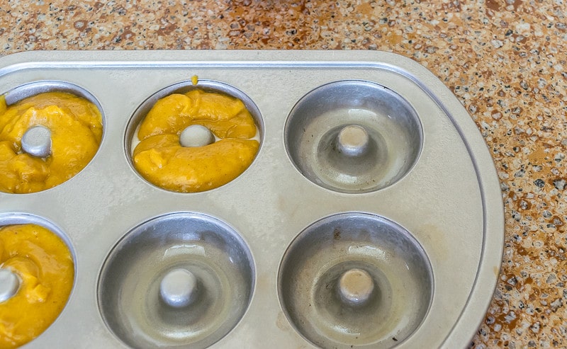 Baked Pumpkin Donut Recipe: donut pan being filled with chai-spiced pumpkin batter