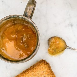 Golden Plum Jam in a cup and on a spoon.