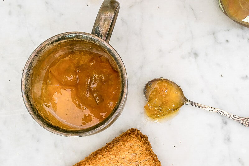 Golden Plum Jam in a cup and on a spoon.