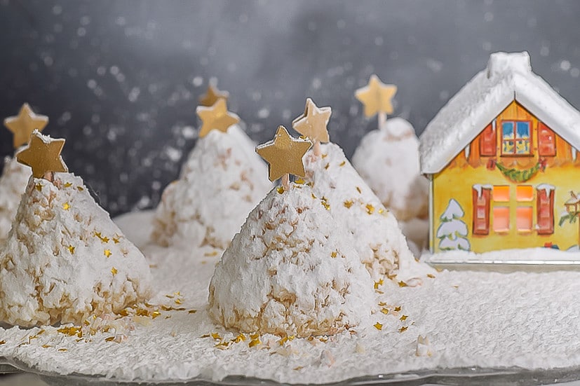 Coconut Christmas Tree Cookie Recipe:"snow covered" Christmas Tree cookies decorated with gold star and gold flake in village setting