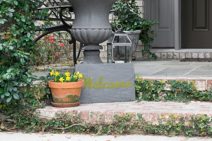 Ideas for decorating a spring front porch, featuring moss and other greenery and a Cricut-made 'moss painted' Welcome sign.