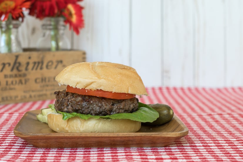 The best hamburger seasoning recipe: perfect hamburger plated on a bun with lettuce, tomato and pickle