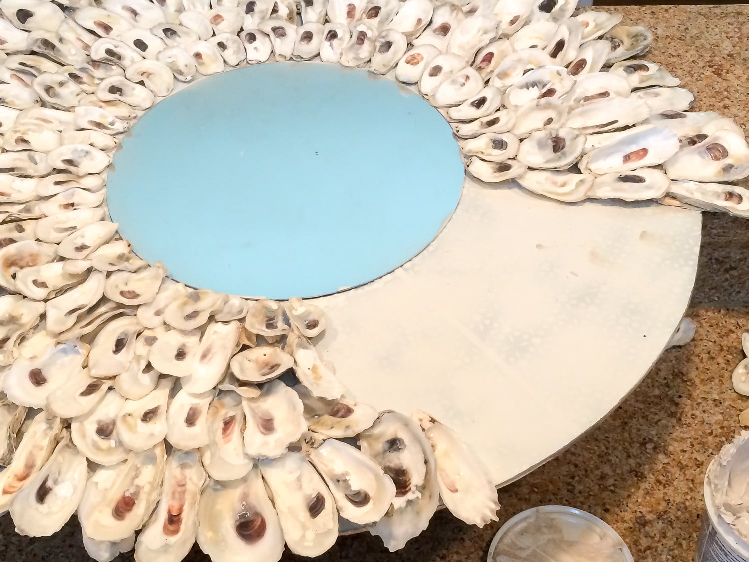 Oyster shells are partially glued on the mirror base.