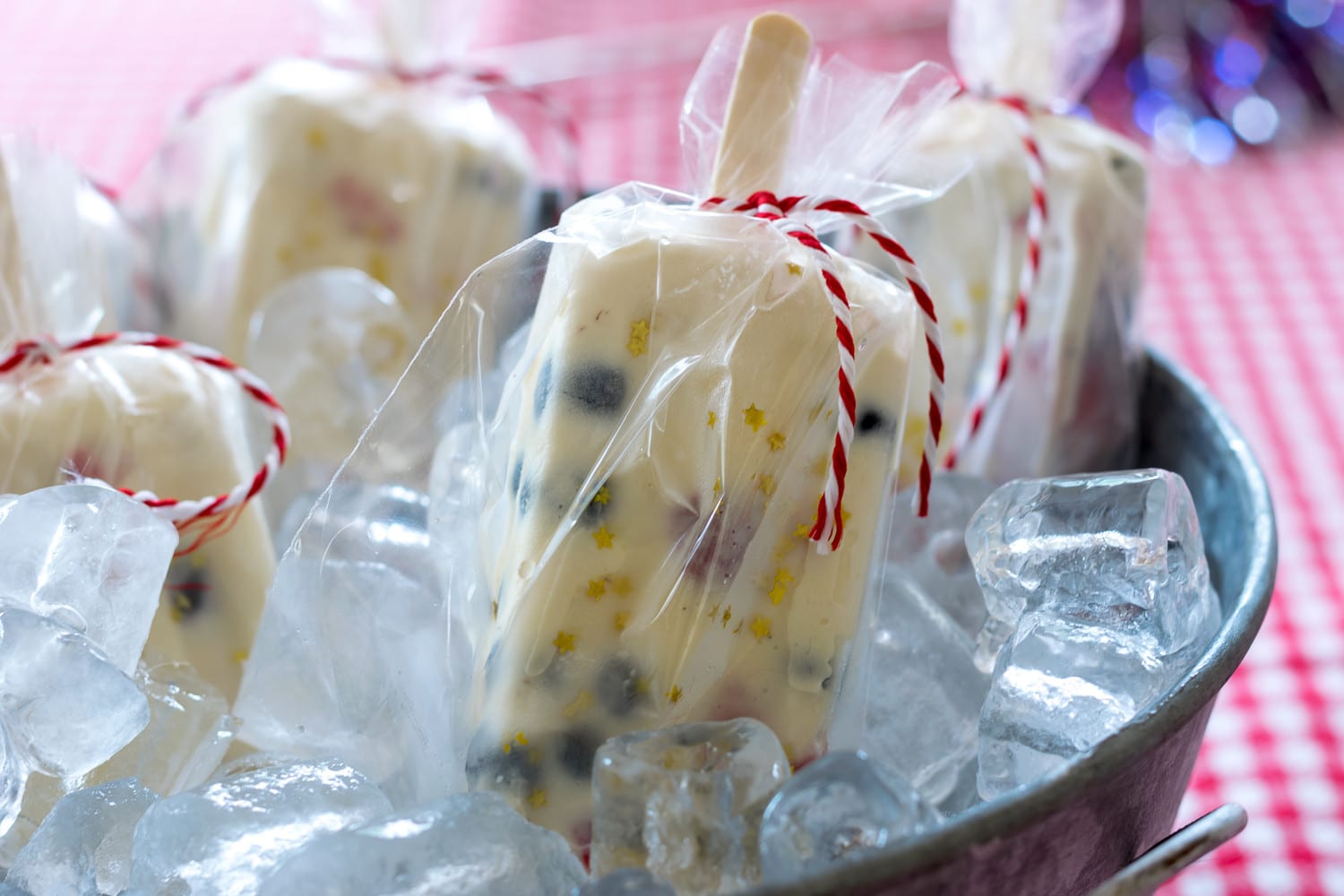 EASY to make red, white and blue ice cream popsicles are perfect for your Fourth of July festivities. Vanilla ice cream, chopped fresh strawberries and fresh blueberries make a perfect ice cream popsicle, made even more perfect with edible gold star sprinkles to up the 4th of July fun.