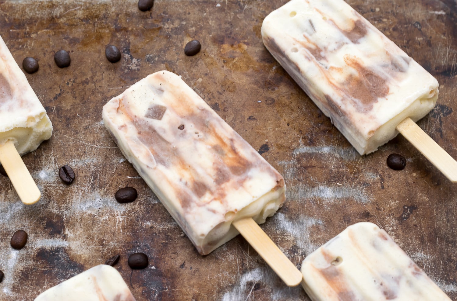 Coffee anyone? Vanilla Ice cream, Chocolate Ribbons and Iced Coffee Cubes make these Iced Mocha Latte Popsicles the perfect hot summer treat.