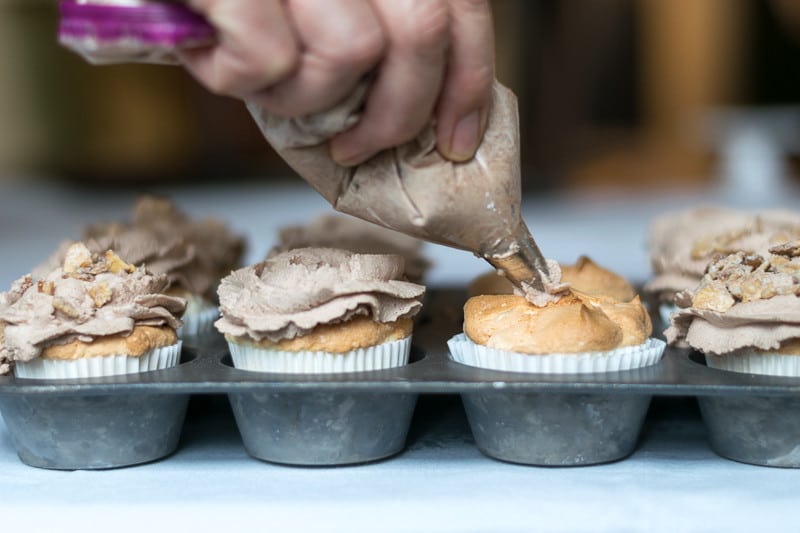 Piping the perfect Kahlua Mocha frosting on the Angle Food Cupcakes.