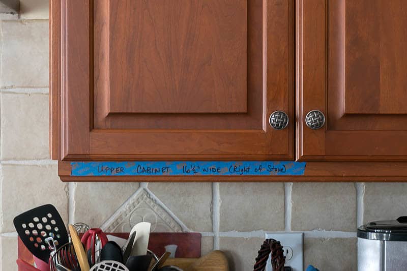 Home downsizing tips: Plan ahead - painters tape on cabinets showing new dimensions 
