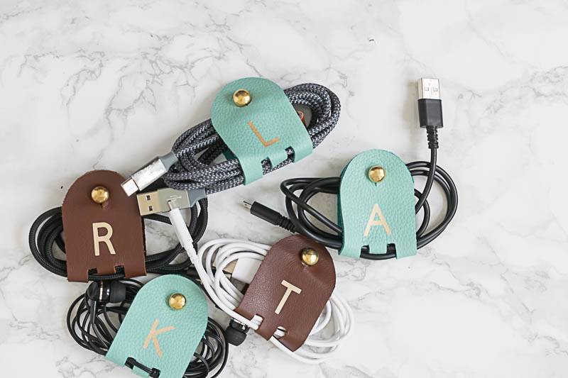 DIY Monogrammed Leather Cord Keepers are fairly quick to make, are so very useful! & make great gifts! Use your Cricut to cut the leather & iron on vinyl.