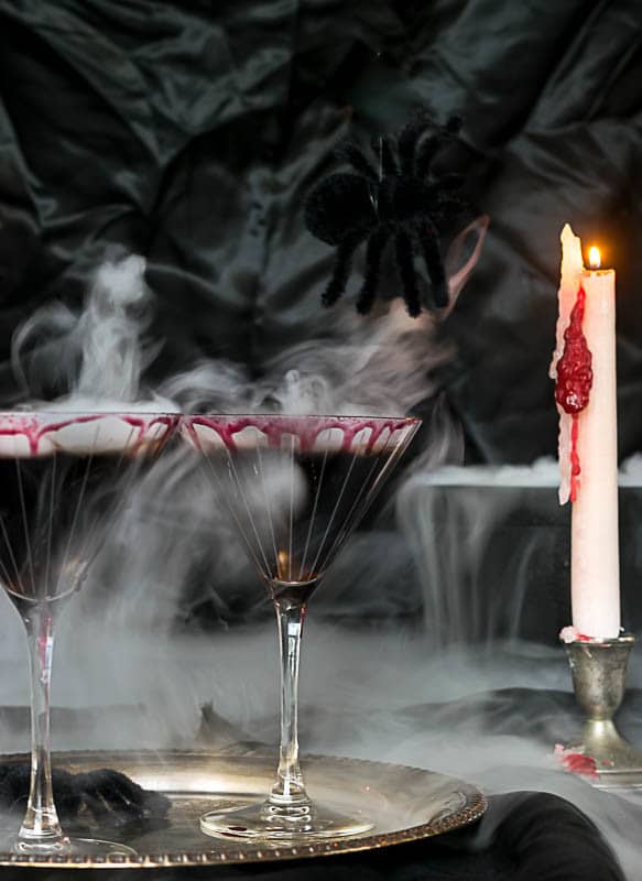 Creepy black margaritas smoking with a candle dripping \'blood\'.