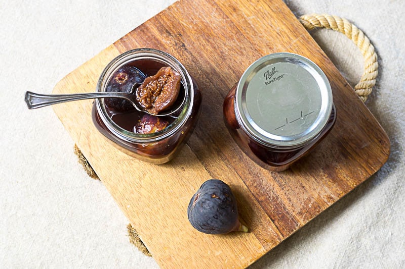jars of figs in spiced honey on a cutting board