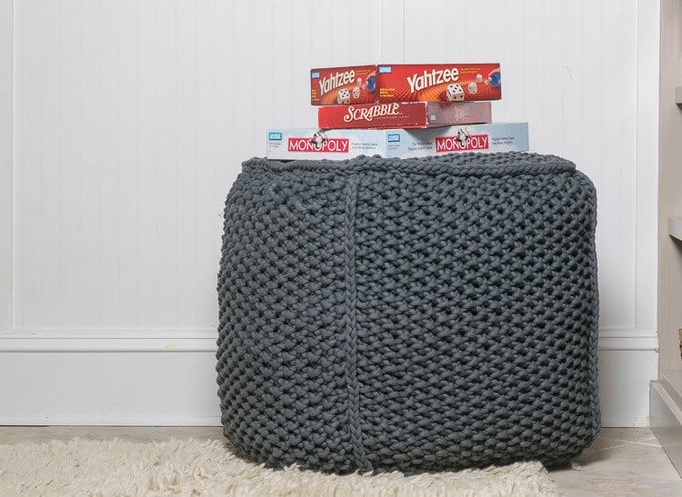 knit pouf with a stack of games.