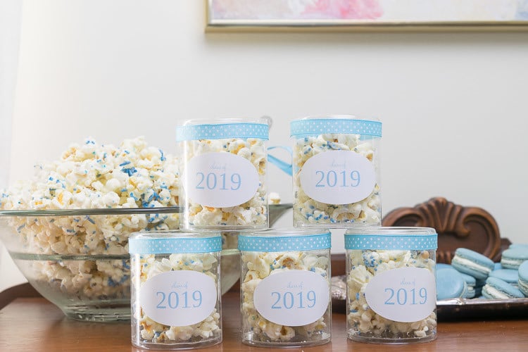 containers with popcorn, labels and ribbon on dessert bar