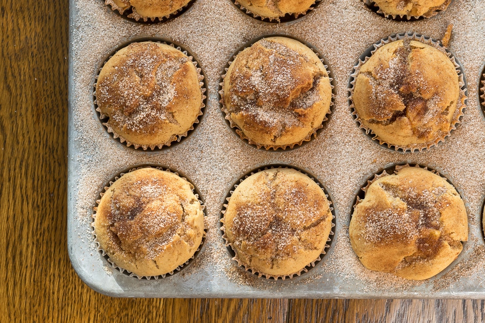 Overhead view of Apple cider muffins sprinkled with sugar and cinnamon in muffin pan 