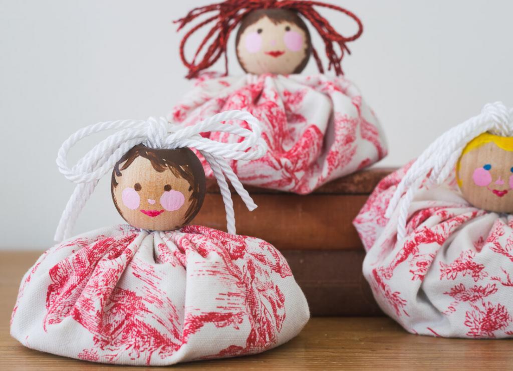Fabric sachets with wooden girl faces.