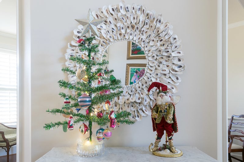 A Christmas tree and a santa on a table.