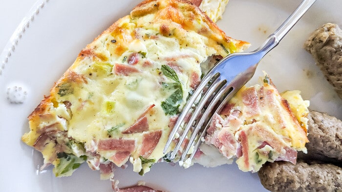 Cutting baked omelet with fork.