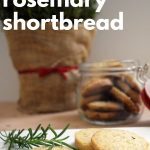 close up of brown butter rosemary shortbread with rosemary bush in the background