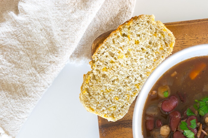 a slice of quick bread near a bowl of soup.