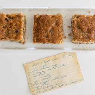 Three date nut bar squares on a white counter.