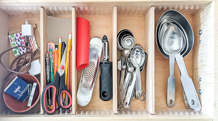 Kitchen utensils in a drawer with dividers.