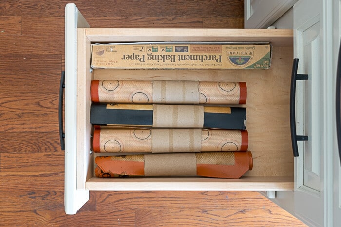 Kitchen organization ideas don't have to be expensive. Paper towel tubes, cut to size, help corral silicone mats