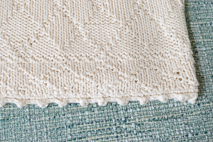 A closeup of the baby blanket showing the knit and purl pattern which creates reversible knitting stitches.