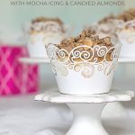 Recipes for Angel Food Cupcakes with Mocha Icing and Candied Almonds on a small stand with several more cupckaes in the back.