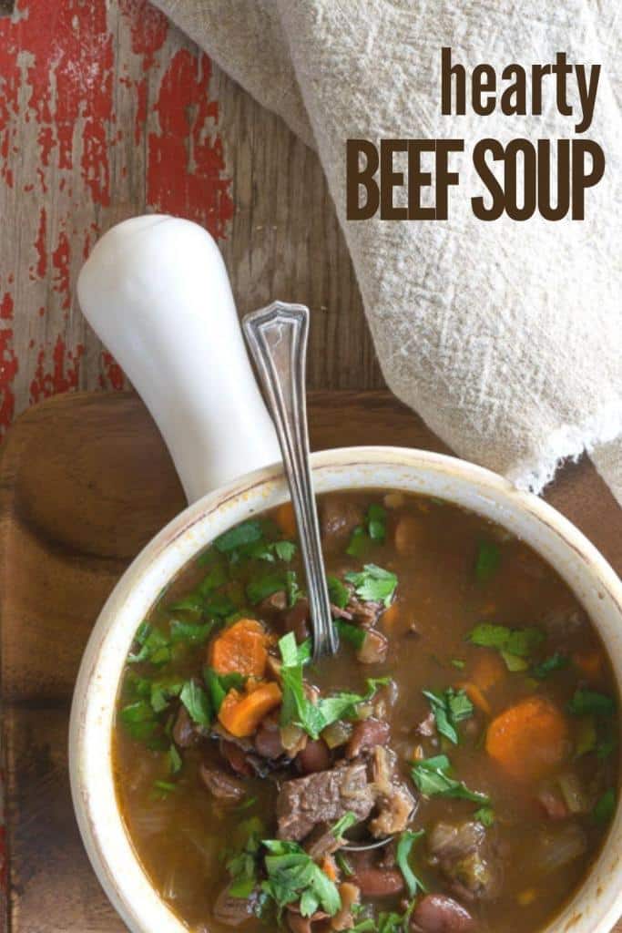 Overhead shot of Hearty Beef Soup in a white bowl with a handle.