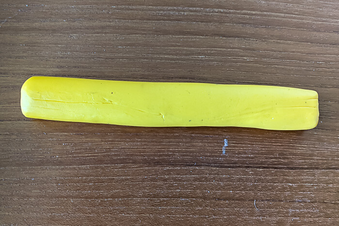 A tube of yellow polymer clay