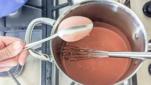 Finger track through strawberry curd on a spoon.