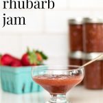 Strawberry Rhubarb Jam in a bowl, with jars of jam and a containe of strawberries in the background.