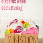 Box of children's clothes and toys to be discarded when decluttering.