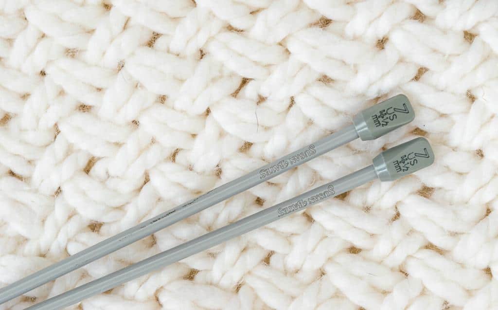 Close up of knob end of knitting needle showing US and metric measurements.
