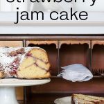 Strawberry Jam Cake on a Pedestal on a wooden hutch.