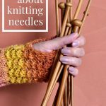 A hand holding a bunch of wooden knitting needles.