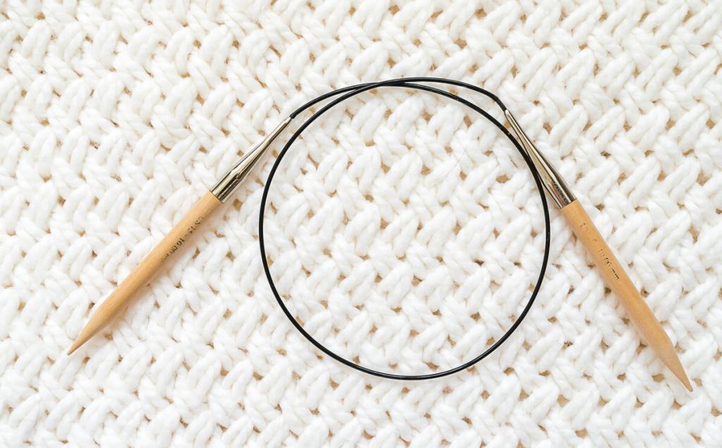 Circular Knitting Needles on a white knit background.