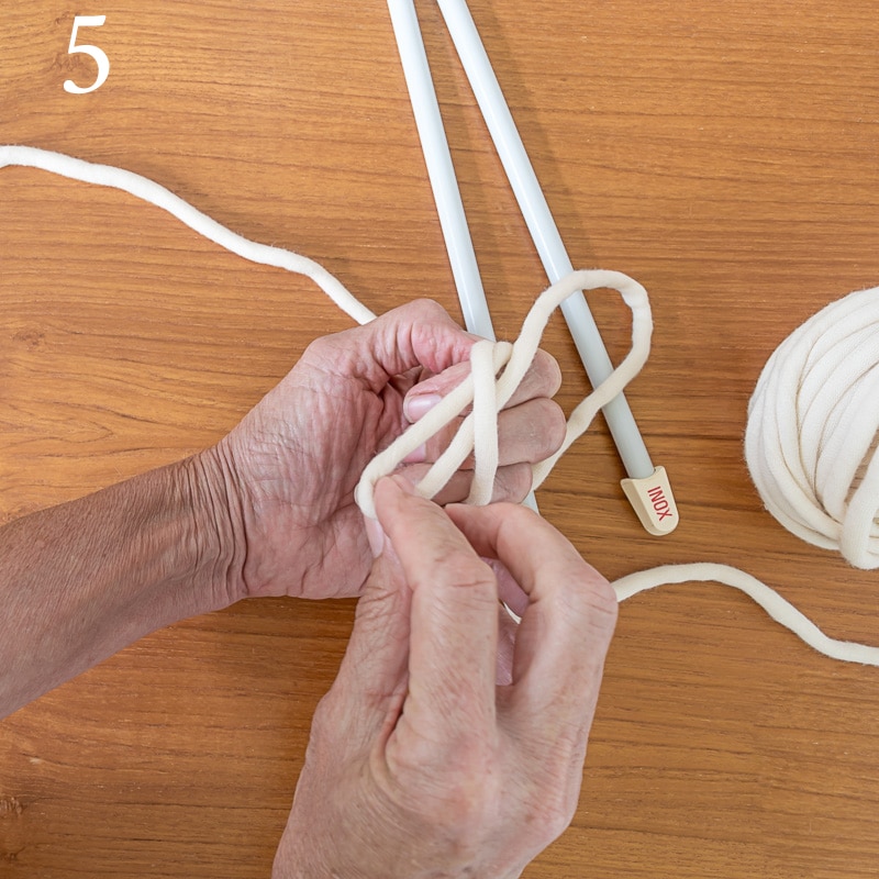 pulling yarn from behind the fingers for making the slip knot.