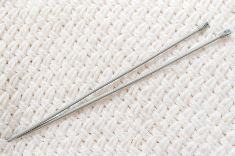 Straight Knitting Needles on a knit background.