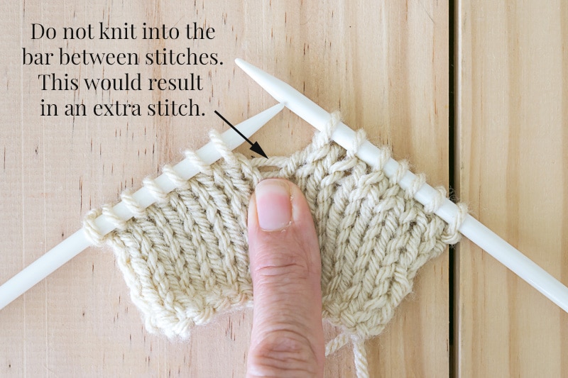 Knit fabric on needles and showing where to not knit to avoid a errant yarn over and a hole in your fabric.
