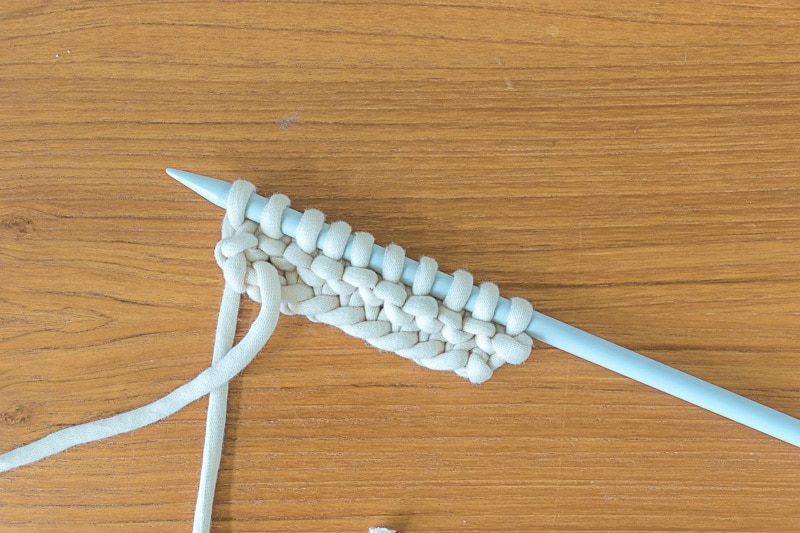 A knitting needle showing 2 rows of knit stitches.